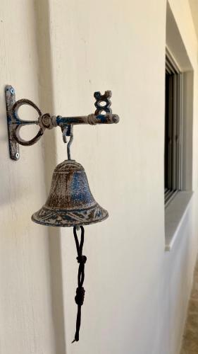 a bell on the side of a wall at CENTRAL APARTMENT PORTOHELI 1 in Porto Heli