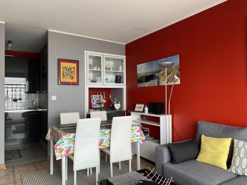 un salon avec une table et des chaises blanches dans l'établissement 470 - Appartement accès direct à la très belle plage de CAROUAL 2km de sable fin, à Erquy