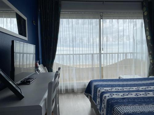 une chambre avec un lit et une grande fenêtre dans l'établissement 470 - Appartement accès direct à la très belle plage de CAROUAL 2km de sable fin, à Erquy