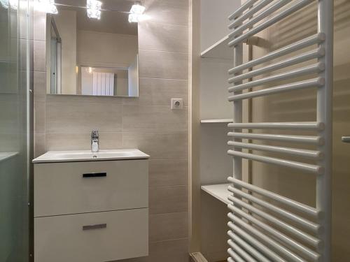 La salle de bains est pourvue d'un lavabo et d'un miroir. dans l'établissement 471 - Appartement T2 avec terrasse pleine vue mer, à Erquy