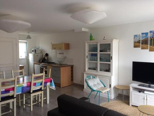 un salon avec un canapé et une cuisine dans l'établissement 485 - Charmante maison à environ 500 mètres de la très belle plage de Caroual, à Caroual