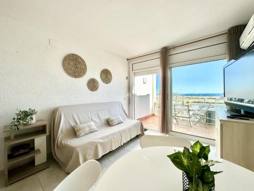 ein Wohnzimmer mit einem weißen Sofa und einem großen Fenster in der Unterkunft Apartment VISTA BAHIA 23 -3 SEA VIEW Empuriabrava in Empuriabrava