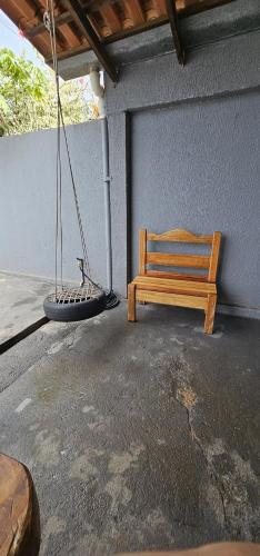 a wooden bench sitting on the side of a building at Casa em Caldas Novas in Caldas Novas