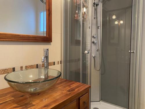 La salle de bains est pourvue d'un lavabo en verre et d'une douche. dans l'établissement 487 - Maison T3, sur la plage de Caroual, à Caroual