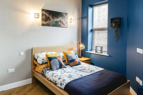 a bedroom with blue walls and a bed with pillows at Crystal Palace 2 Bedroom Flat in Crystal Palace