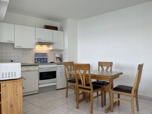 une cuisine avec une table et des chaises en bois dans l'établissement 501 - Appartement 1 chambre à Erquy, à proximité du port, en bordure de la plage du centre, à Erquy