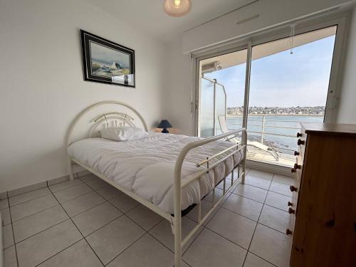 - un lit blanc dans une chambre avec balcon dans l'établissement 501 - Appartement 1 chambre à Erquy, à proximité du port, en bordure de la plage du centre, à Erquy