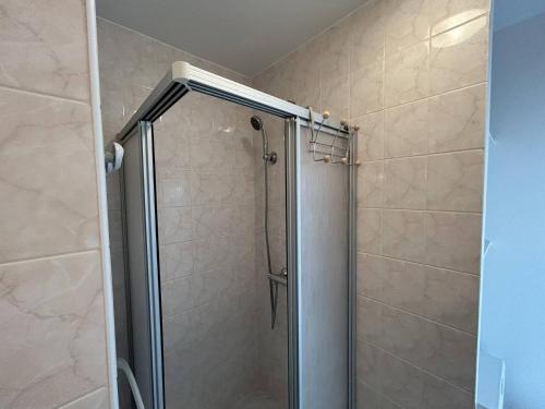 une douche avec une porte vitrée dans une salle de bain dans l'établissement 501 - Appartement 1 chambre à Erquy, à proximité du port, en bordure de la plage du centre, à Erquy
