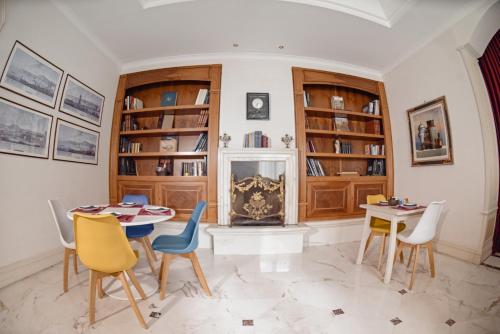 a living room with a table and chairs and a fireplace at Al centro Luxury Home in Caserta