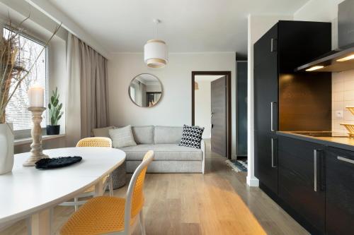 a kitchen and living room with a table and a couch at Elite Apartments Marine Brzeźno in Gdańsk