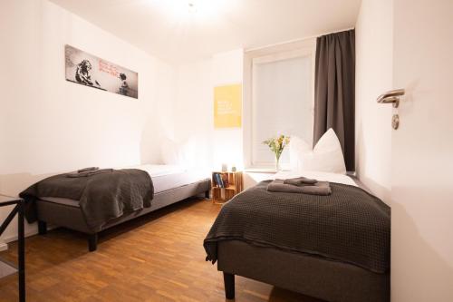um quarto de hotel com duas camas e uma janela em Ko-Living - Yellow Submarine Suite - Altstadt - Küche - 2 SZ - getrennte Betten - bis 7 Gäste em Halle an der Saale