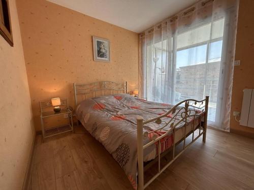 une chambre avec un lit et une grande fenêtre dans l'établissement 504 - A Erquy, en bordure de la plage du centre, à 800m des commerces, à Erquy