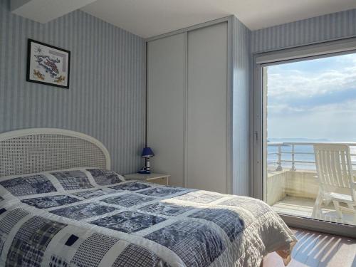 1 dormitorio con cama y vistas al océano en 505 - A ERQUY, située en bordure de la plage du centre, à 800m des commerces, en Erquy