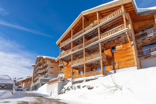 un grande edificio in legno nella neve di Résidence Les Portes du Grand Massif - Flaine a Flaine