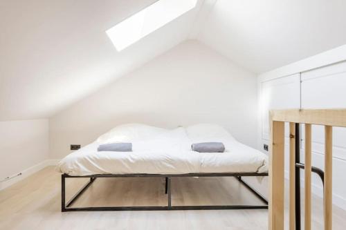 a white bedroom with a bed in a attic at SéSé in Vinkeveen