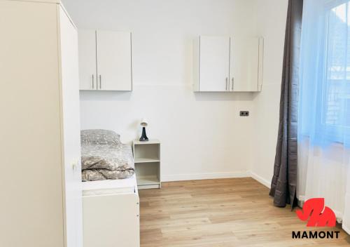 a room with white cabinets and a wooden floor at Schöne, große Monteurwohnung in Bremen