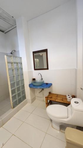 a bathroom with a toilet and a sink at Kinti Guest House in Máncora