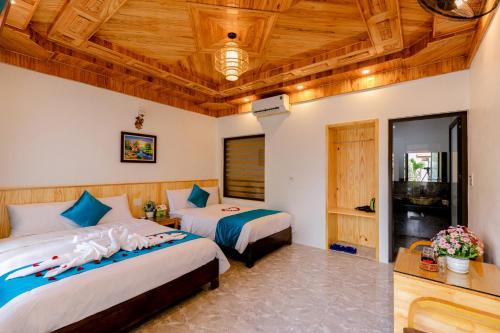 um quarto com 2 camas e um tecto de madeira em Tam Coc Green Mountain Homestay em Ninh Binh