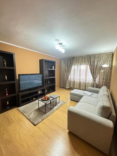 uma sala de estar com um sofá e uma televisão de ecrã plano em RED Dhomes . Near Nymphaea em Oradea