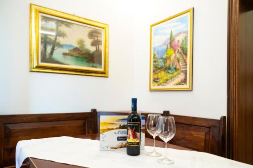 - une bouteille de vin assise sur une table avec 2 verres à vin dans l'établissement Casa degli Affreschi Tuscany, à San Rocco a Pilli