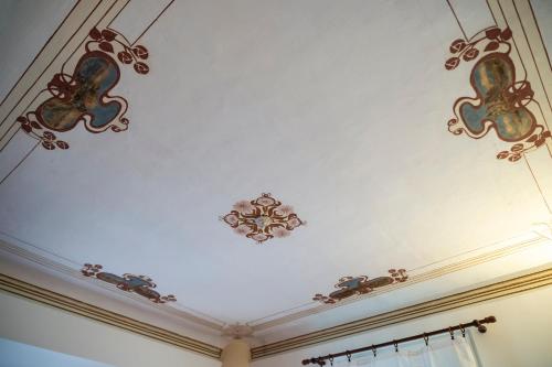 een wit plafond met kroonluchters erop bij Casa degli Affreschi Tuscany in San Rocco a Pilli