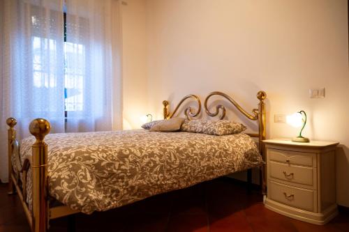 a bedroom with a bed and a dresser and a window at Casa degli Affreschi Tuscany in San Rocco a Pilli