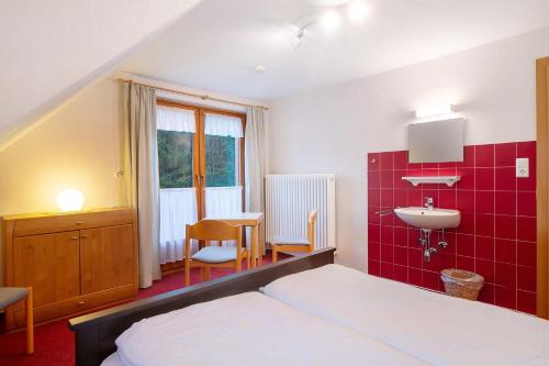 een slaapkamer met een bed, een wastafel en een tafel bij Haus Johanna in Todtmoos