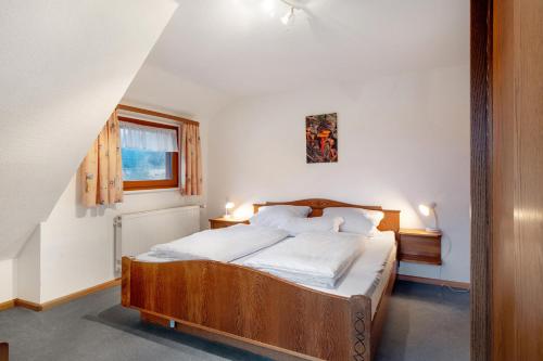 een slaapkamer met een houten bed met witte lakens bij Haus Johanna in Todtmoos