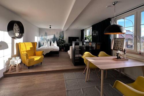 ein Wohnzimmer mit gelben Stühlen und einem Tisch in der Unterkunft Weimarer Modern Woody Apartment in Buttelstedt