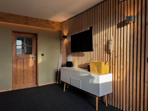 Zimmer mit einem TV an einer Holzwand in der Unterkunft Weimarer Modern Woody Apartment in Buttelstedt