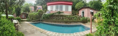 a house with a swimming pool in a yard at Aum 108 Retreat - Rishikesh Mountains in Rishīkesh
