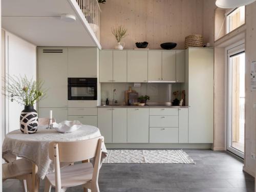 una cucina con mobili bianchi e tavolo di Waterfront Cabins a Göteborg