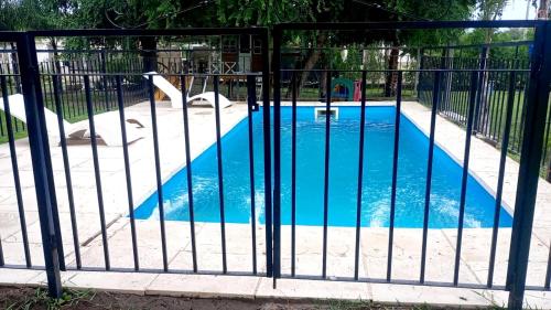 una piscina detrás de una valla con un tobogán. en Finca y temporarios la BENDECIDA en Santiago del Estero