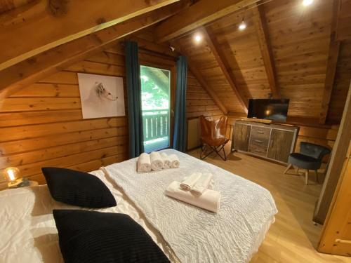 a bedroom with a bed in a log cabin at LE RENARD Chalet en bois in La Bresse