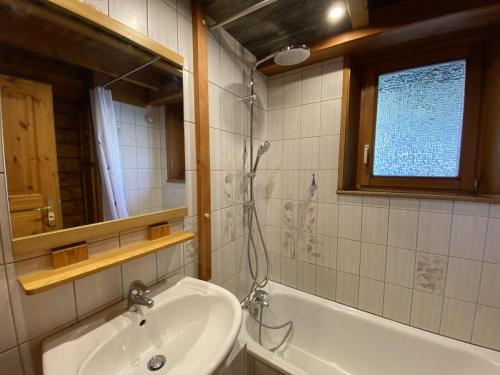 a bathroom with a sink and a tub and a mirror at LE RENARD Chalet en bois in La Bresse