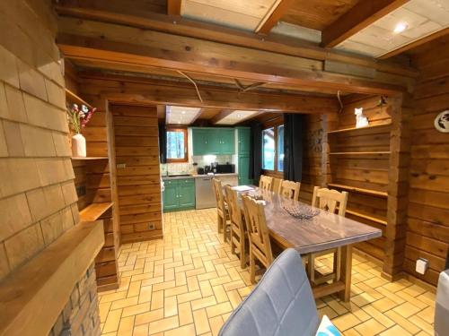 une cuisine et une salle à manger avec une table et des chaises dans l'établissement LE RENARD Chalet en bois, à La Bresse