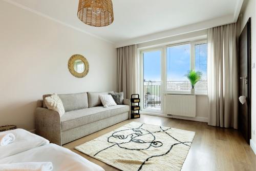 a living room with a couch and a window at Elite Apartments Marine Brzeźno in Gdańsk