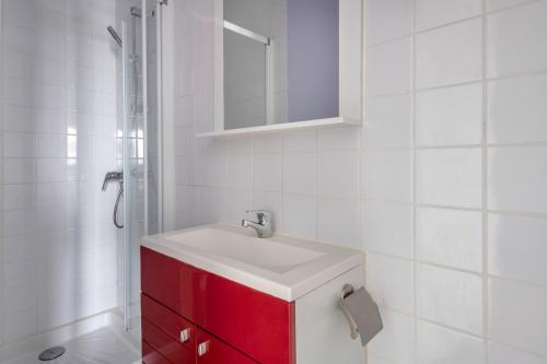 La salle de bains est pourvue d'une armoire rouge et d'un lavabo. dans l'établissement Appartement Vue mer pour 4 à 50m Plage, à La Plaine-sur-Mer