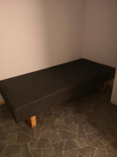 a black bed in a corner of a room at Best no1 in Manndalen