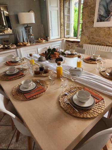 une table avec des assiettes et des verres dans l'établissement Chambres d'hotes Le Bernes, à Vic-Fezensac