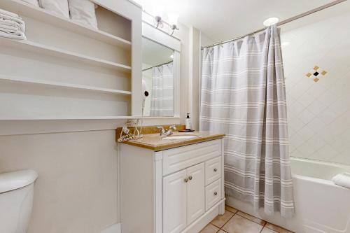 y baño blanco con lavabo y ducha. en Baytowne Wharf - Pilot House #207, en Destin