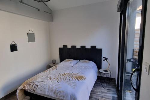 een slaapkamer met een bed en een groot raam bij Jolie maison dans un quartier très calme in Martignas-sur-Jalle