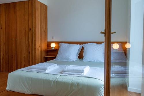 1 dormitorio con 1 cama con toallas en The Escape en Ponta Delgada