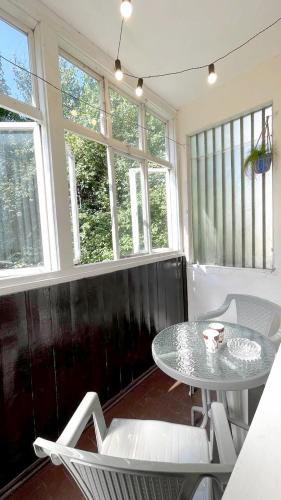 a table and chairs in a room with windows at 3 кімнатна затишна та комфортна квартира in Chernivtsi
