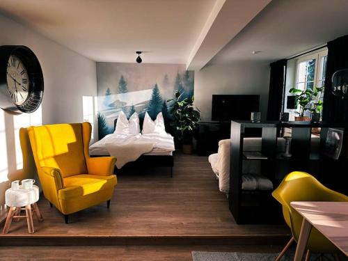 uma sala de estar com 2 camas e uma cadeira amarela em Urban Apartments Weimarer Land em Buttelstedt