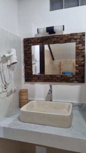 a bathroom with a sink and a mirror at Sansari Villa Sanur in Sanur