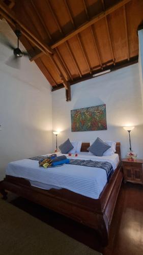 a bedroom with a large bed with blue pillows at Sansari Villa Sanur in Sanur