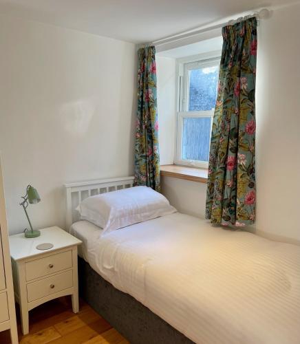 two twin beds in a bedroom with a window at The Queen's Head Hotel in Buxton