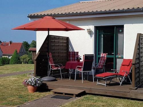 a deck with a table and chairs and an umbrella at Muschelsucher - Sünnenkieker WE10 - ABC250 in Beckerwitz