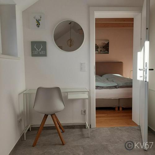 a room with a chair and a mirror and a bed at Jogilation in Sankt Jakob im Walde